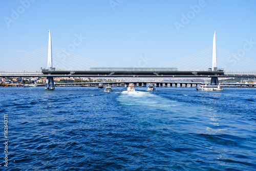 Golden Horn Metro Bridge and tourboats on sea in İstanbul, Turkey photo