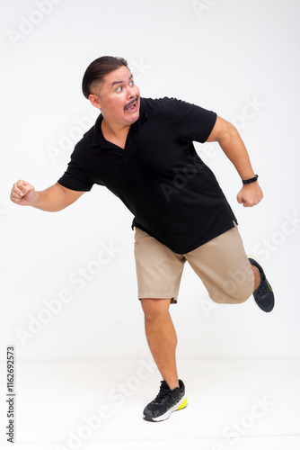 A terrified middle-aged man fleeing while looking back, running away to save his life. Showing urgency, isolated on a white background. Whole body photo.