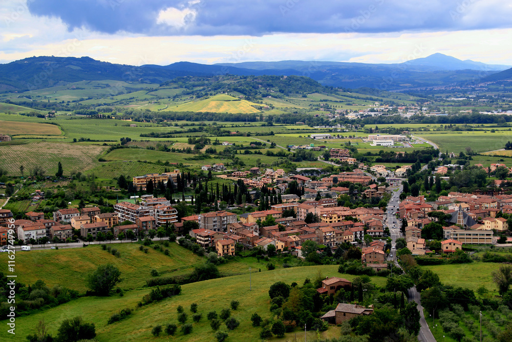 Obraz premium Aerial landscape view of one of the towns in the suburbs of Orvieto against the backdrop of mountains and a stormy sky in the Umbria region, Italy