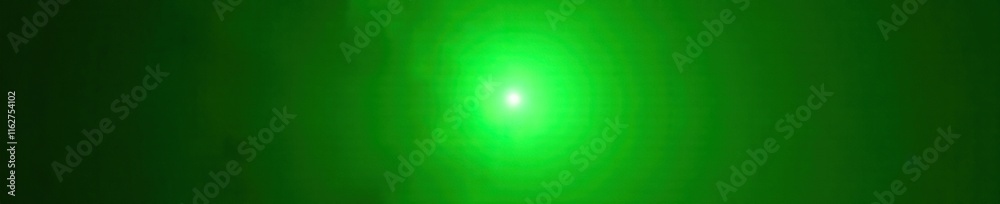 Obraz premium Bright green lens flare against dark backdrop, sunspot, glowing spot, bright green