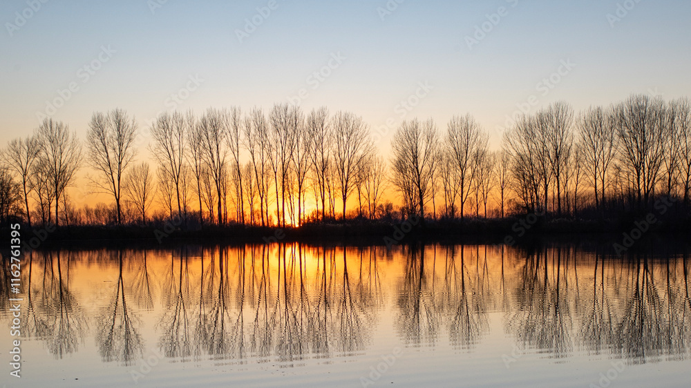 Obraz premium tramonto all'orizzonte riflesso nell'acqua del lago