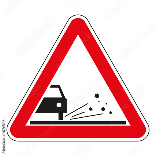 Red triangular road sign warning of loose road surface with gravel or chippings flying from under car wheels