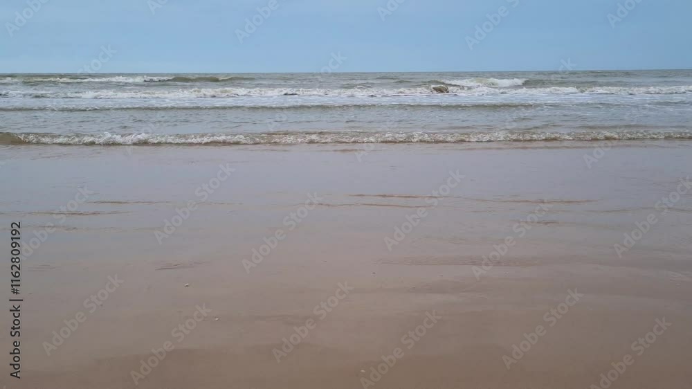 Beautiful view of waves on the beach in the afternoon when the weather is cloudy Beautiful view of waves on the beach in the afternoon when the weather is cloudy