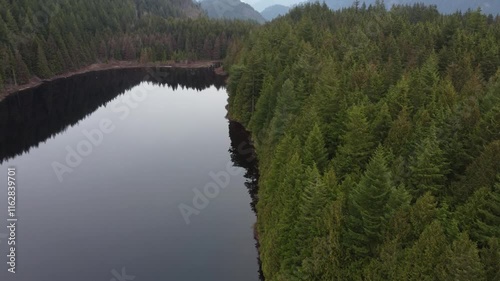 Wallpaper Mural Floating through nature’s calm: a lake and rolling green hills under clouds Torontodigital.ca