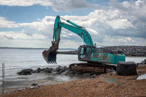 Bulldozer working on a breakwater construction photo