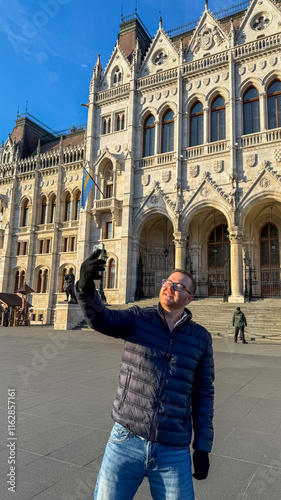 Photography A man of Caucasian descent takes a selfie in front of the historic Hungarian Par