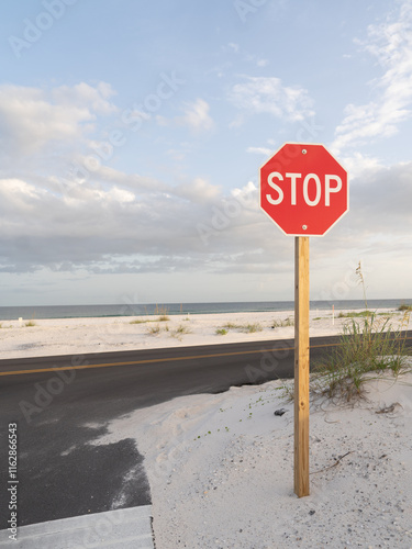 Stop Sign Before A Cloudy Beach Sunset photo