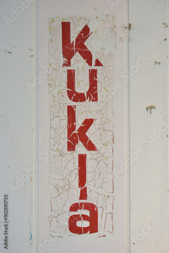 kukla red letter with craquelure effects on white dirt background