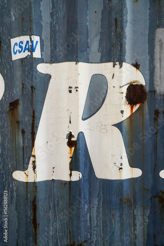 white R letter sign writing on blue metal background