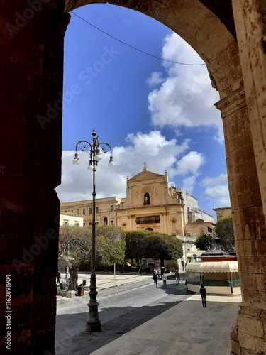 La chiesa di San Salvatore a Noto incorniciata da un arco del portico di Palazzo Ducezio. photo