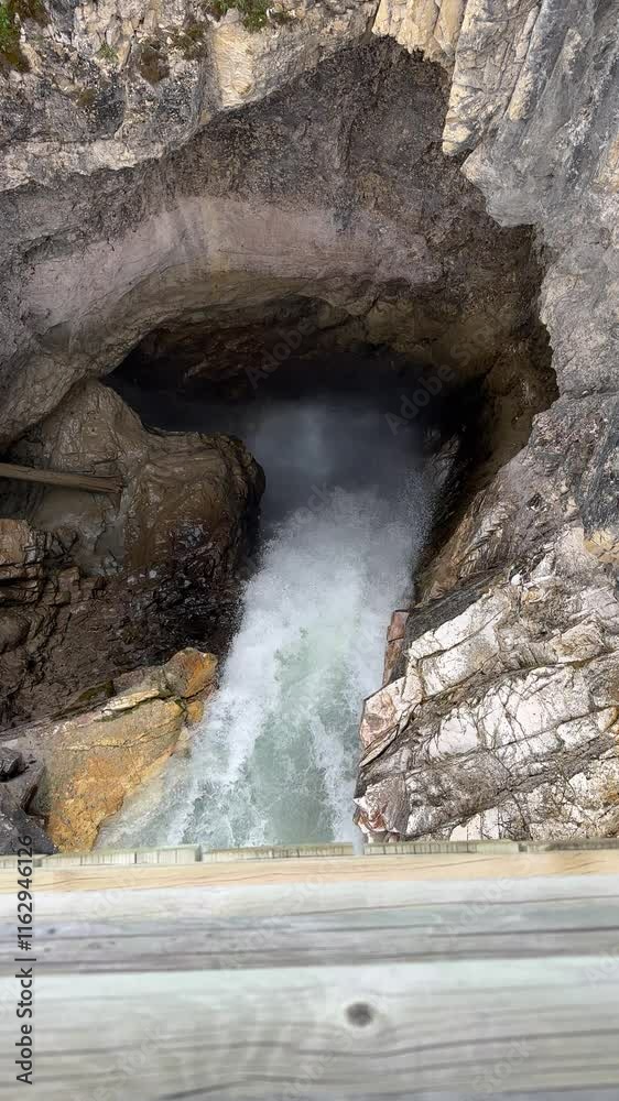 A powerful waterfall plunges into a rocky cavern, creating mist and echoing sounds. The rugged cliff walls frame this dramatic natural spectacle.
A powerful waterfall plunges into a rocky cavern, creating mist and echoing sounds. The rugged cliff walls frame this dramatic natural spectacle.