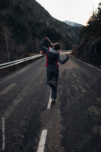 A woman in the high mountains walking along the road photo