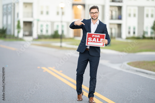 A man in a suit is holding a sign that says 