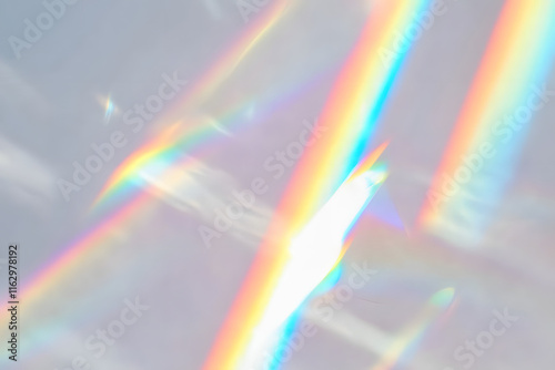 Blurred rainbow light refraction texture overlay effect for photo and mockups. Organic drop diagonal holographic flare on a white wall. Shadows for natural light effects