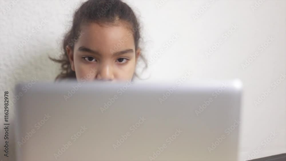 Young girl using laptop computer, looking at screen Young girl using laptop computer, looking at screen