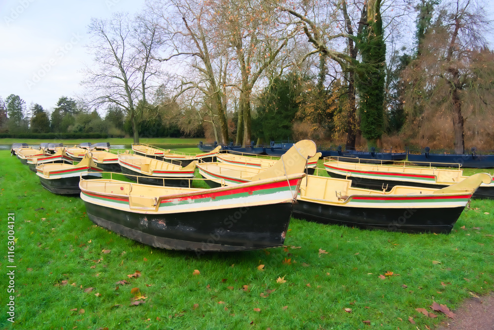 Obraz premium Rowboats Resting on Green Grass in a Park