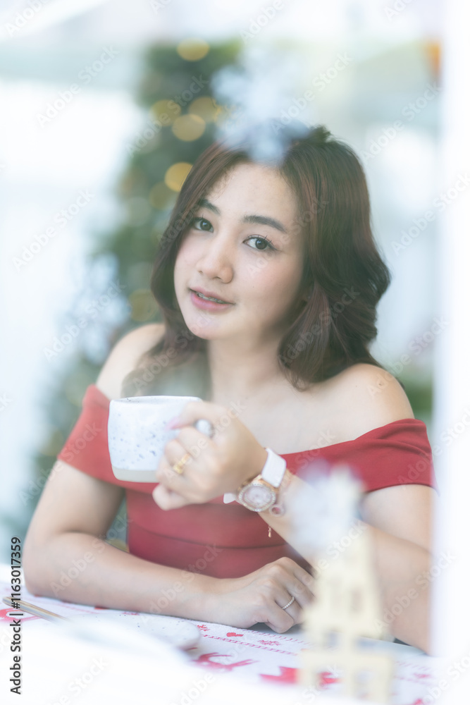 beautiful asian woman relaxing In a red dress holding of positive the having cup of coffee or chocolate at home in the living room indoors Decoration During Christmas x-mas and New Year holiday.