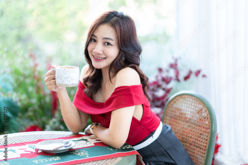 beautiful asian woman relaxing In a red dress holding of positive the having cup of coffee or chocolate at home in the living room indoors Decoration During Christmas x-mas and New Year holiday.