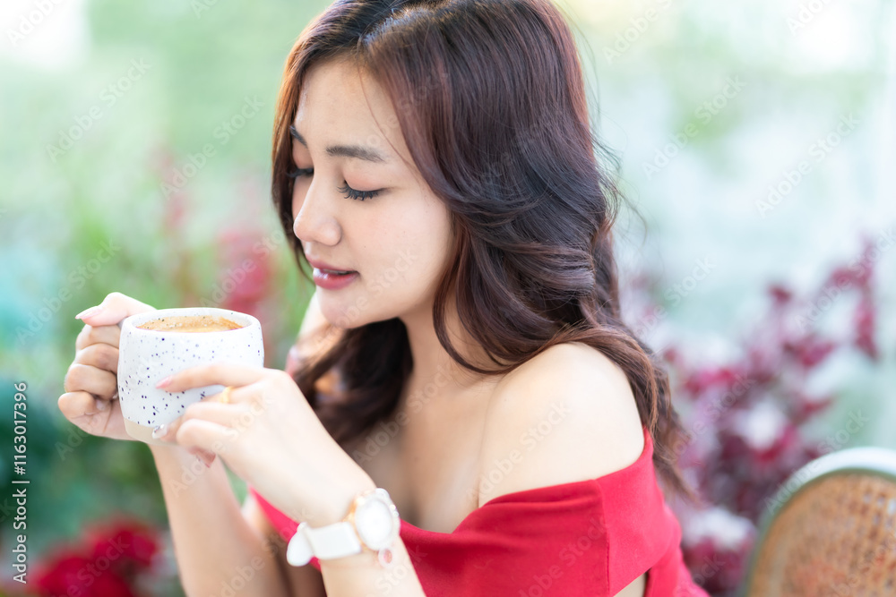 beautiful asian woman relaxing In a red dress holding of positive the having cup of coffee or chocolate at home in the living room indoors Decoration During Christmas x-mas and New Year holiday.