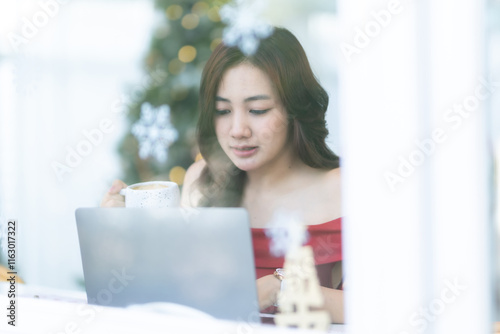 asian freelance people business female talking making using casual working with laptop computer and coffee at home in the living room indoors Decoration During Christmas x-mas and New Year holidays.