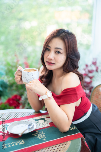 Obraz na płótnie beautiful asian woman relaxing In a red dress holding of positive the having cup of coffee or chocolate at home in the living room indoors Decoration During Christmas x-mas and New Year holiday. w salonie