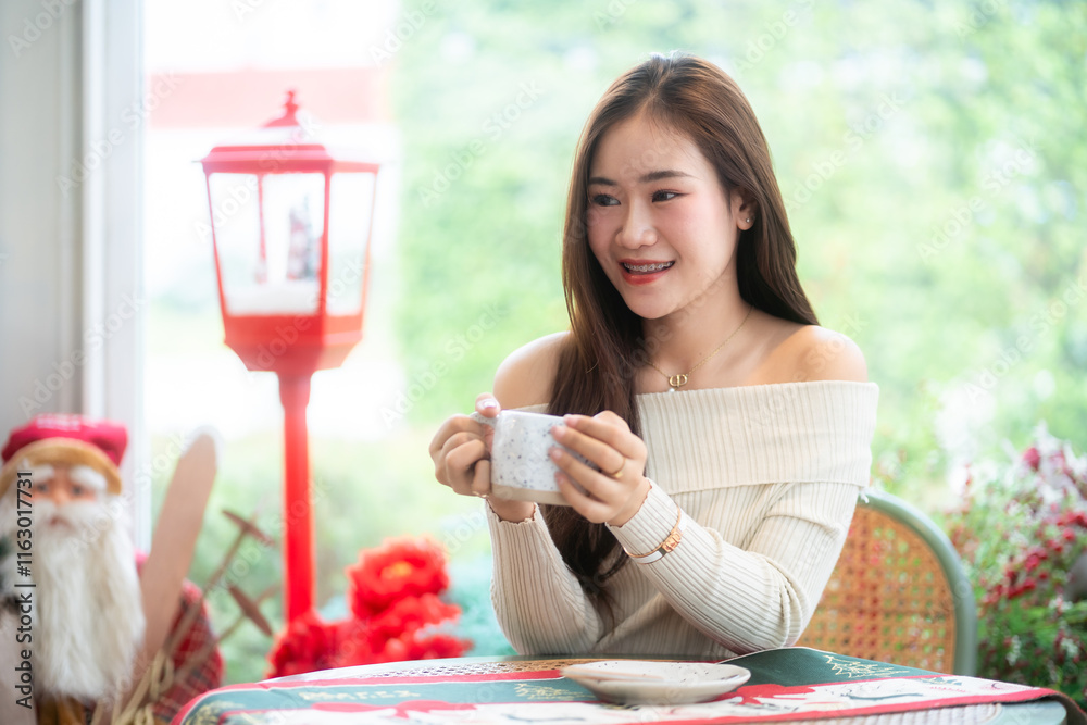 Portrait beautiful asian woman holding of positive the having cup of coffee,milk or chocolate at home in the living room indoors Decoration During Christmas x-mas and New Year holidays.