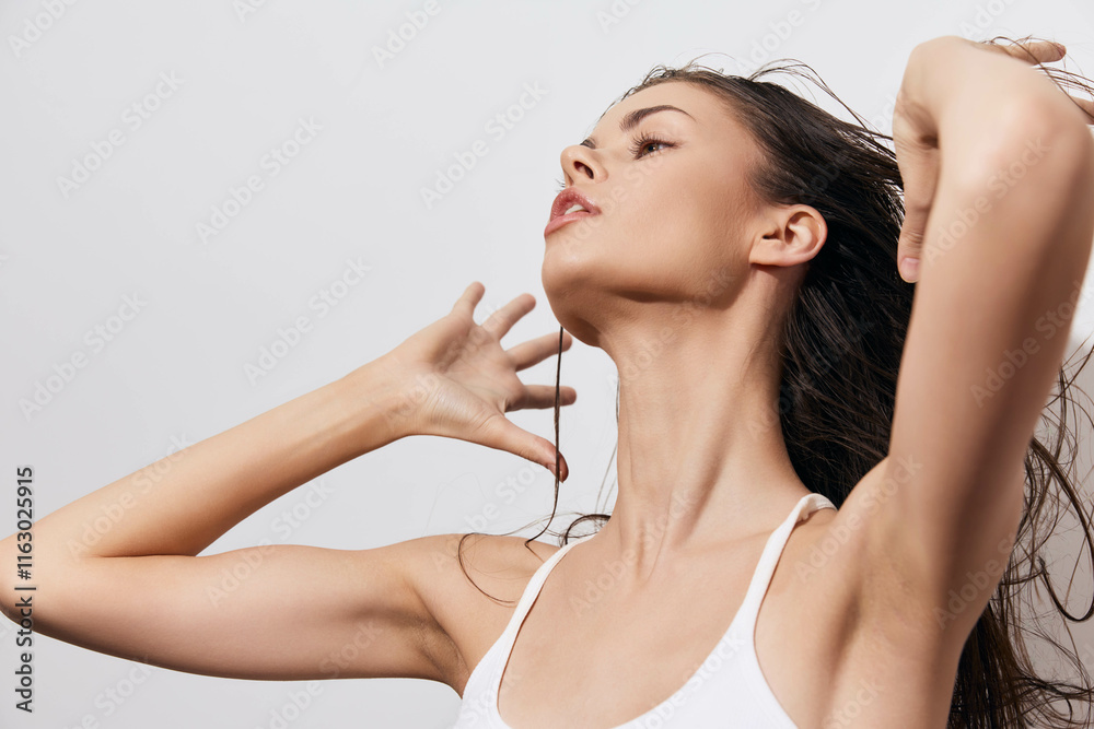 Portrait of a confident young woman with flowing hair, showcasing elegance and beauty against a soft gray background A dynamic pose highlighting her graceful neck and expressive features Portrait of a confident young woman with flowing hair, showcasing elegance and beauty against a soft gray background A dynamic pose highlighting her graceful neck and expressive features