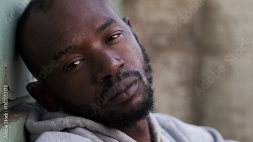 depressed and upset youngblack man alone looking the camera photo