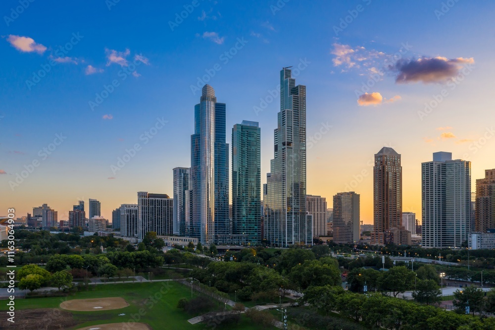 Fototapeta premium Chicago skyline at sunset, viewed from Millennium Park. Modern high-rises contrast with parkland. Beautiful city scene. Grant Park, Chicago, Illinois, United States