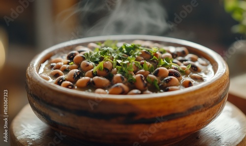 A steaming bowl of black-eyed peas topped with fresh herbs. photo