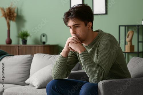 Depressed young man sitting...