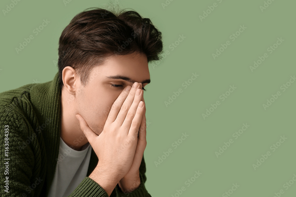 Depressed young man on green background, closeup Depressed young man on green background, closeup