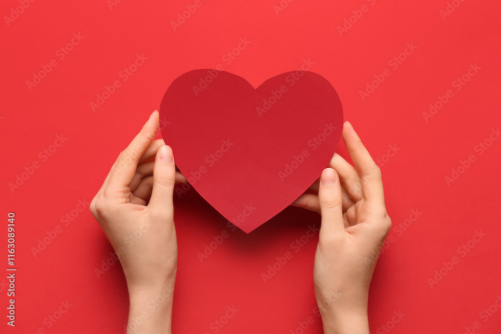 Female hands with red paper heart on color background. Valentine's Day celebration Female hands with red paper heart on color background. Valentine's Day celebration