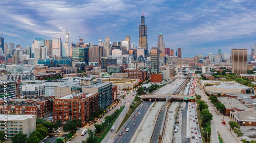 Naklejka premium Chicago skyline at twilight, showing city streets, highways, and train tracks. Traffic flows through the urban landscape. West Loop, Chicago, Illinois, United States Of America