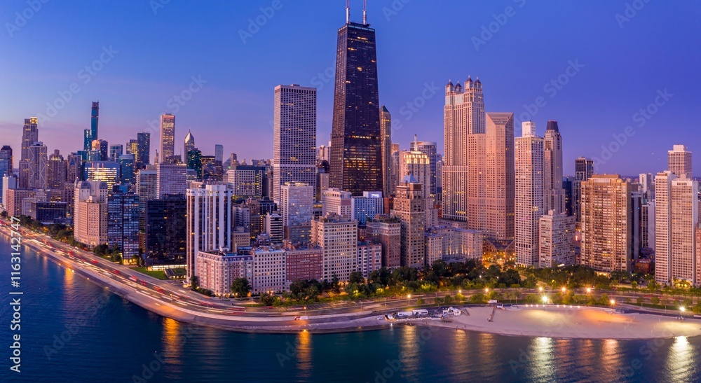 Fototapeta premium Chicago skyline at twilight, illuminated skyscrapers, traffic on lakefront road, tranquil beach. Downtown, Chicago, Illinois, United States Of America