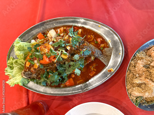 Deep fried seabass with three type of sauce, sweet, spicy and sour, famously known as Ikan Siakap 3 Rasa photo