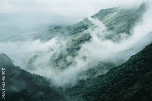 Lush green valley surrounded by majestic mountains and soft clouds in a serene morning landscape