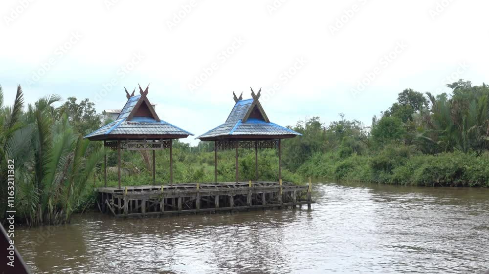 Pagoda structures on river bank in Indonesia. Swallow house in background. Pagoda structures on river bank in Indonesia. Swallow house in background.