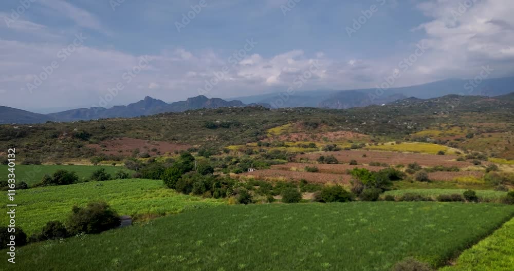 Aerial shot of crop fields surrounded by the Tepoztlán mountains in Mexico Aerial shot of crop fields surrounded by the Tepoztlán mountains in Mexico