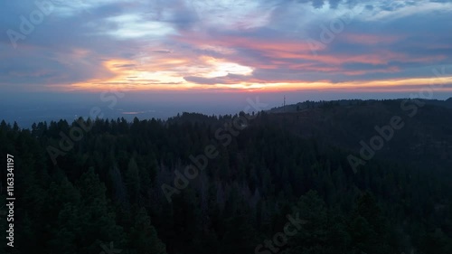 Sunset on top of mountain over looking city photo