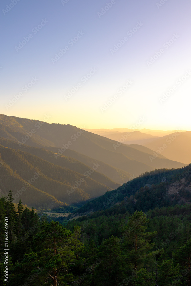 Forest covered mountain range with haze at sunset Forest covered mountain range with haze at sunset