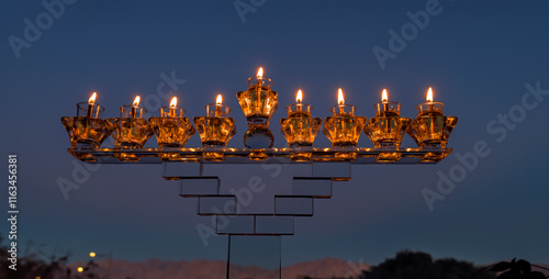 Crystal festive menorah and burning olive oil in decorative jar candles. Main...