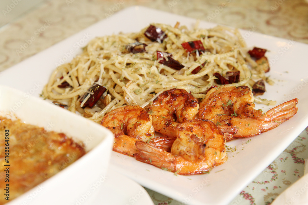 Spaghetti stir-fried with chili, garlic and grilled shrimp, fusion Thai food, selective focus, close-up Spaghetti stir-fried with chili, garlic and grilled shrimp, fusion Thai food, selective focus, close-up