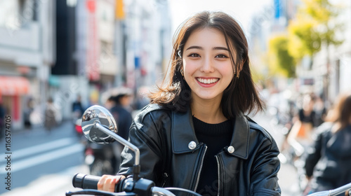 Japanese woman in black leather jacket sitting on a motorbike at city street