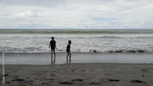 Children Playing by the Shore at Gasan Gadang Beach photo