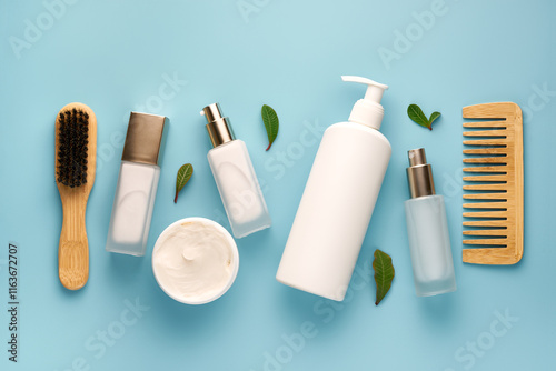 Flat lay composition with wooden brushes and different hair products on light blue background