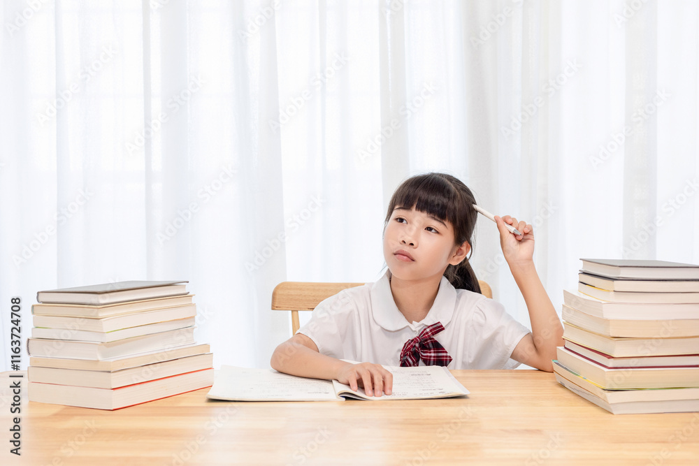 The little Chinese girl is doing homework at home The little Chinese girl is doing homework at home
