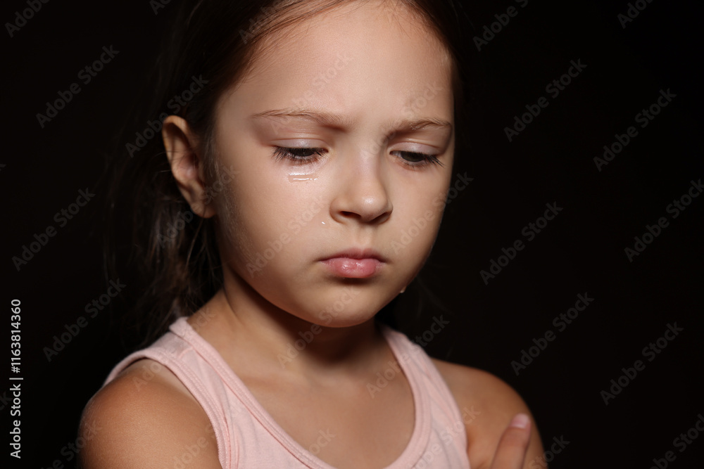 Fototapeta premium Orphanage concept. Sad girl on black background