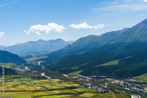 Under the blue sky and white clouds, the Qilian Mountains are covered in snow.