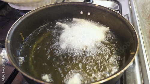 putting the fresh dough in the frying oil - cooking the pettole - South of Italy photo